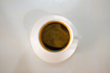 Coffee. Fresh Espresso with Crema Foam on White Table Background.