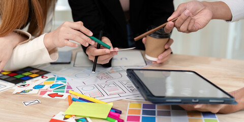 Collaborative UX UI team examining design notes and sketches while engaging in a creative discussion