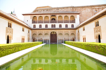 View of the Court of the Myrtles, with a large pool, located in the Comares Palace inside the Alhambra. It is one of the main monuments of Granada, Spain.