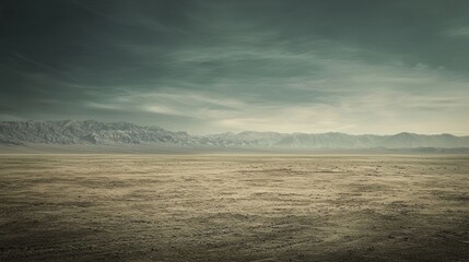 Obraz premium Vast Desert Landscape Under a Moody Sky: Awe-Inspiring Panorama of Arid Terrain and Distant Mountains