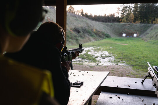 Training shooting weapons at an outdoor shooting range.
