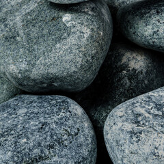Dry rough round dark stones close up
