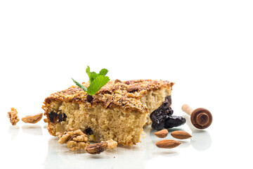 Ruddy sponge cake with prunes and nuts for tea, isolated on white background