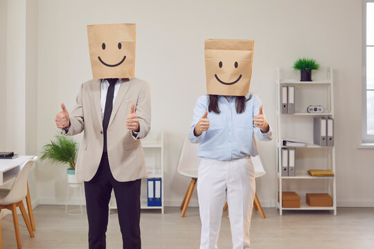 Portrait of a business coworkers wear paper mask with smiling and positive emotion, standing together in office. They gesture thumbs up, positive attitude and cheerful demeanor in the workplace.