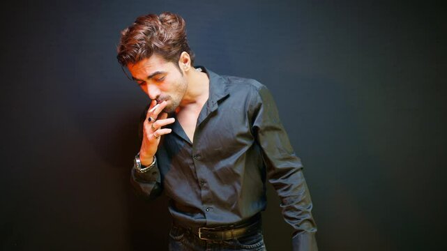 Man stands smoking with a worried face