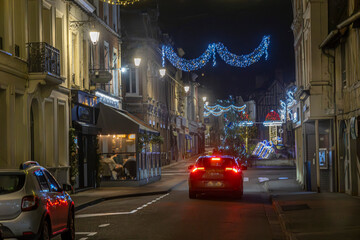 Normandy, France -12- 30- 2024 : Exterior night photo view of christmas light decorations for xmas celebrations decor evening with garlands and tinsel lights,