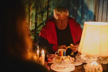 Portrait of a gray-haired grandfather celebrating a family holiday with his relatives in a cozy atmosphere