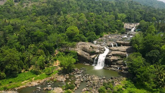 Aerial Drone Shot of a Tranquil Waterfall Flowing Down the Hills of Munnar
