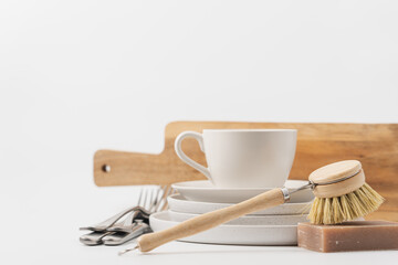Zero waste cleaning tools and Clean white dishes on white background with copy space. Cleaning, dishwashing concept background