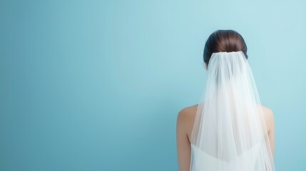 A captivating image of a bride from the back, showcasing a delicate veil and elegant wedding dress. Soft natural light enhances the romantic atmosphere.