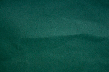 Abstract crumpled dark green paper background creased texture
