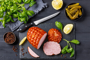 boneless smoked ham on black slate board, top view