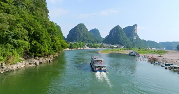 Aerial view following cruise boat on the Li river, summer in Yangshou, China