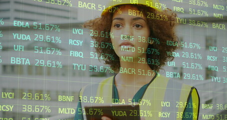 Image of financial data processing over biracial female architect using tablet