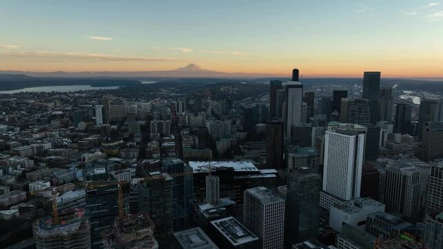 Seattle city skyline at dusk with Mt Rainer on the horizon in orange sunlight