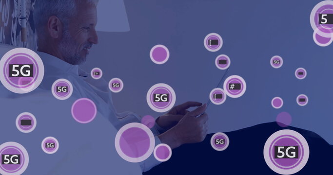 Image of 5g text and digital icons processing over caucasian businessman using tablet - Powered by Adobe