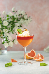 Grapefruit and orange jelly dessert garnished with whipped cream and mint