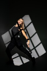 Young dancer performing with window-shaped shades on background