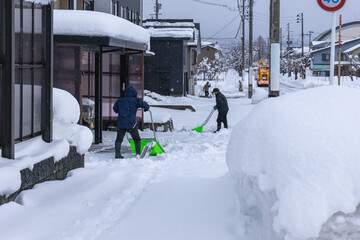 住宅前の除雪をする高齢者夫婦