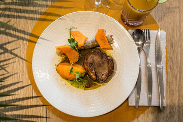 Une viande et des patates dans une assiette dans un restaurant gastronomique