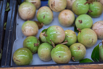 Full background heap of Star apple Vietnamese breast milk fruit or Vu Sua at grocery store shelf in Hanoi, Vietnam, fresh harvested kenitu, caimito, boob milk fruit tropical family Sapotaceae