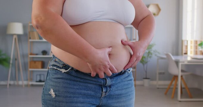 Obese woman with excessive belly visceral fat posing at home, chubby overweight plus size big fat fit lady with no progress in weight loss after sport, dieting, in despair not changing or improving 