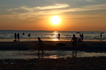 Fototapeta premium Silhouettes of tourists at Bang Saen beach in the evening.