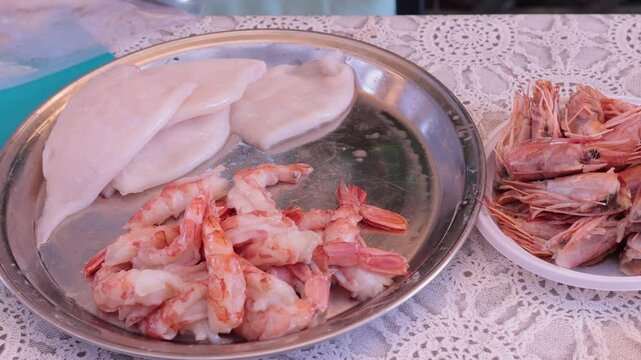 Scallops without shells, shrimp and squid on a plate, cooking seafood