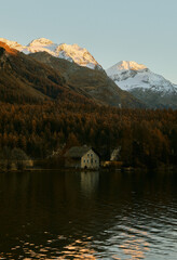 Fototapeta premium Sonnenuntergang in den Bergen. Haus steht am Bergsee. Goldener Herbst. 