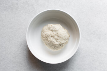 Overhead view of chinese scallion pancake dough on white countertop, top view of homemade scallion pancake dough, process of making cong you bing
