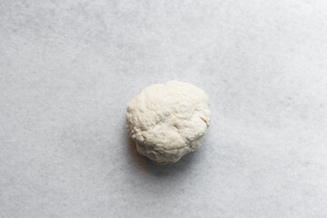 Overhead view of chinese scallion pancake dough on white countertop, top view of homemade scallion pancake dough, process of making cong you bing