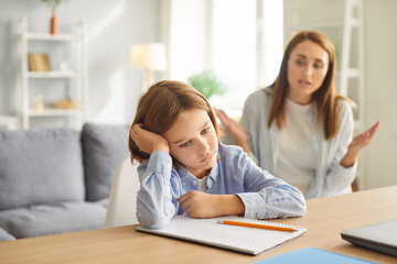 Angry mother scolding student son during homework session at home. A family quarrel highlighting online learning challenges, parenting, and the importance of patience in education.