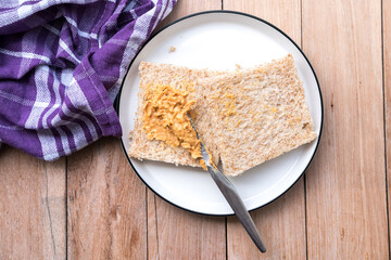 Peanut butter being spread on whole wheat bread. A simple and classic snack or breakfast