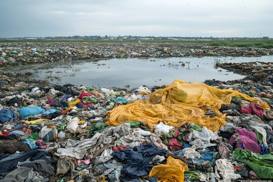 Landfill site polluting water with plastic and textile waste