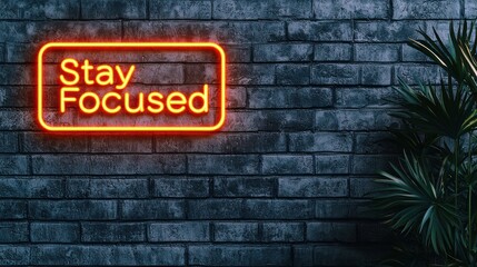 A vibrant neon sign reading "Stay Focused" illuminates a textured brick wall, accompanied by a lush green plant, creating a motivational ambiance.