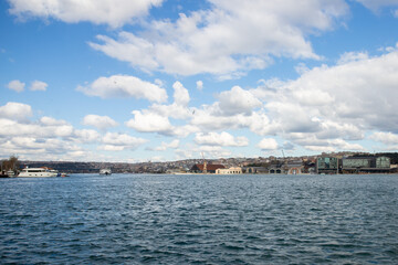 Istanbul cityscape, mosque domes and minarets at sunset, scenic harbor with ships and water.