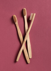 Beige bamboo toothbrushes on a dark red concrete top view. Zero waste and no plastic concept