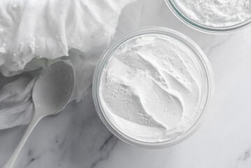 homemade greek style yogurt in a glass bowl on white marble table.