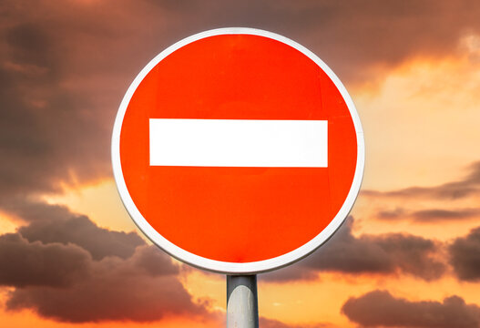 Stop road sign, no entrance sign against the backdrop of an alarming crimson sky
