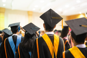Students in Graduation Ceremony. Students wearing academic gowns and caps attend their graduation...