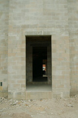 Leading line through framed doorway of a concrete block house under construction. Unfinished block view all the way through to light.
