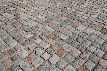 Background of bricks road. Background with bricks road. Stone cladding pavement. Brick surface background. Rough brick road. Stone pavement texture.