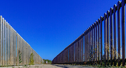 fenced wooden bridge over dunes on the beach road
