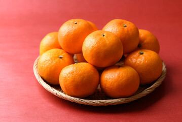 Mandarin tangerine orange fruit in basket on red background, Lucky food in Lunar New Year or Chinese New Year
