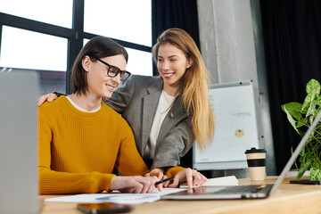 Two young people collaborate eagerly in a modern office, sharing ideas and projects.