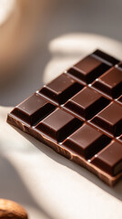 Fototapeta premium Delicious chocolate bar with rich texture and shiny surface on a solid background. 