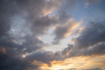 Real sky view of sunset or sunrise. A serene skyscape of sundown with pastel gentle colorful grey, blue and yellow clouds.