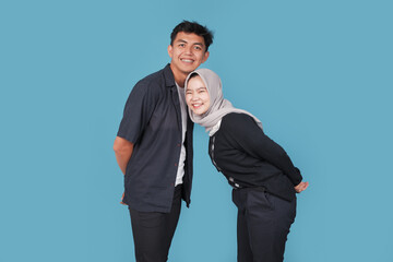 Portrait of Happy asian College man an women with jiba isolated on blue backround. Portrait of happy Asian muslim couple smiling, husband and wife hugging full of love, family concept