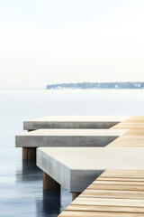 Obraz premium Calm waterfront with wooden dock extending into serene water at sunrise