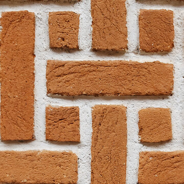 Rustic mud wall with geometric pattern of brown clay blocks industrial exterior